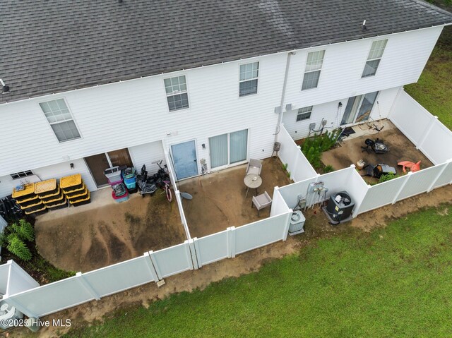 back of house featuring a fenced backyard, a shingled roof, central AC, and a patio