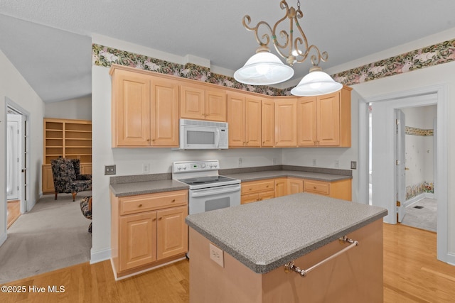 kitchen featuring white appliances, light brown cabinetry, light wood-style floors, and a center island