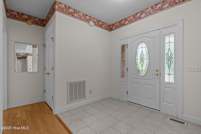 entryway featuring baseboards and a textured ceiling