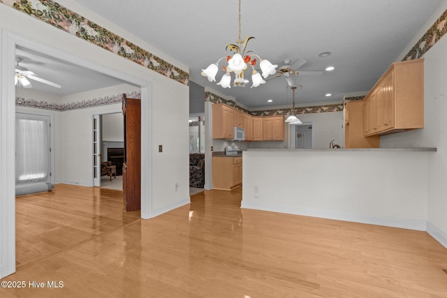 kitchen with ceiling fan, light wood-type flooring, light brown cabinets, baseboards, and white microwave
