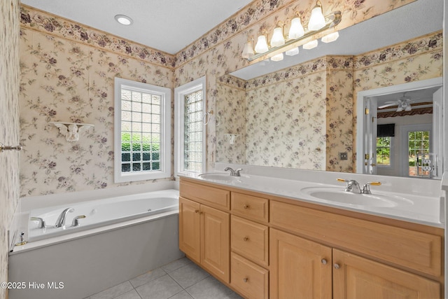 full bath featuring tile patterned floors, a bath, double vanity, and wallpapered walls