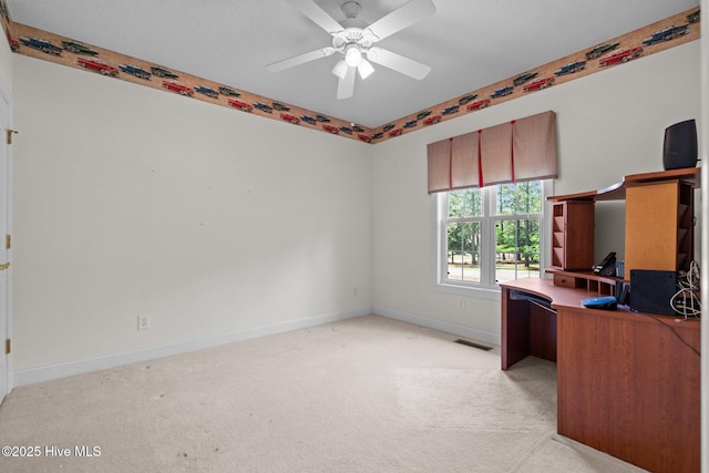 unfurnished office featuring light carpet, baseboards, and ceiling fan