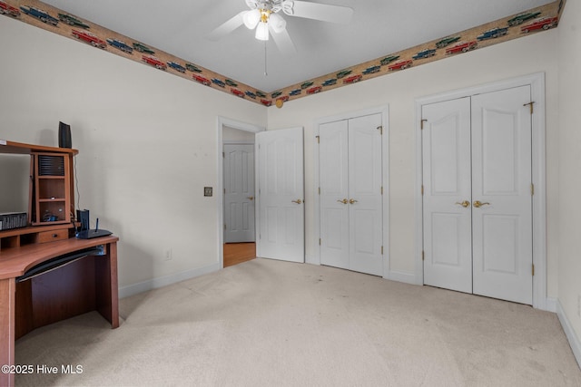 unfurnished office featuring carpet, a ceiling fan, and baseboards