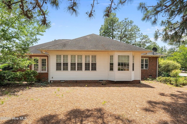 back of property with crawl space and a shingled roof