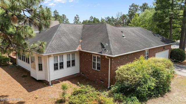 back of house featuring crawl space, a garage, a shingled roof, brick siding, and driveway