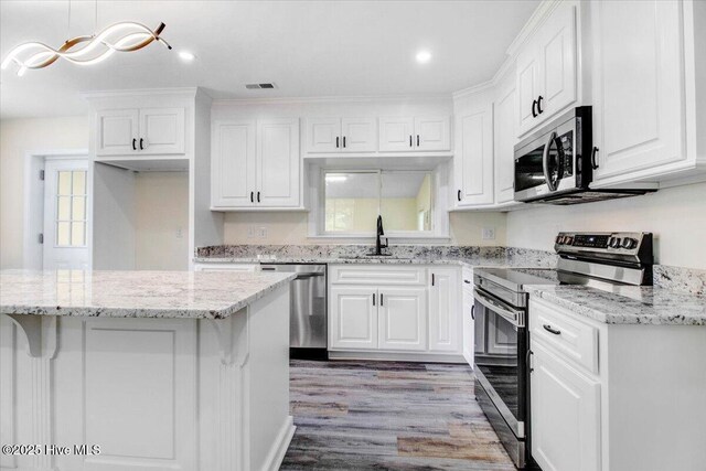 406 Mercer St, Goldsboro, NC 27530 - kitchen featuring appliances with stainless steel finishes, a sink, white cabinets, healthy amount of natural light, and recessed lighting