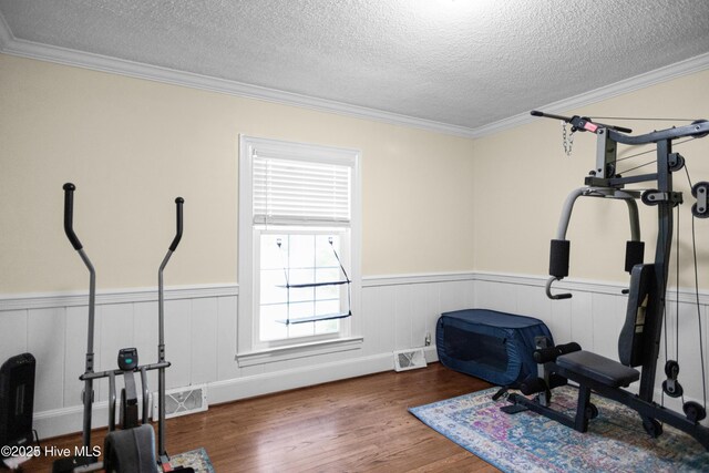 2008 S Elm St, Greenville, NC 27858 - workout room with a wainscoted wall, wood finished floors, a textured ceiling, and ornamental molding