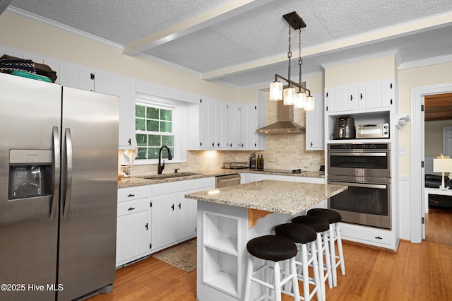 2008 S Elm St, Greenville, NC 27858 - kitchen featuring stainless steel appliances, a sink, wall chimney range hood, light wood-style floors, and a textured ceiling