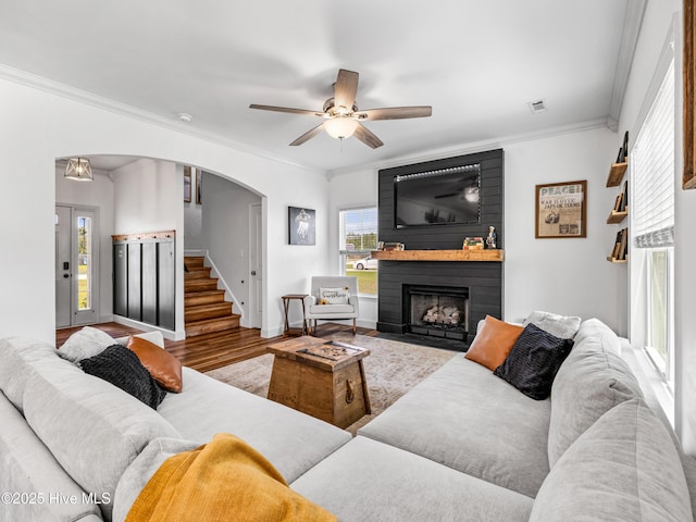 118 Prospect Dr, Richlands, NC 28574 - living area featuring arched walkways, wood finished floors, ornamental molding, a large fireplace, and a ceiling fan