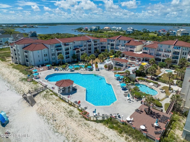 community pool with a patio area and a water view
