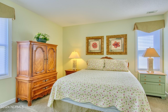 bedroom with light colored carpet and baseboards