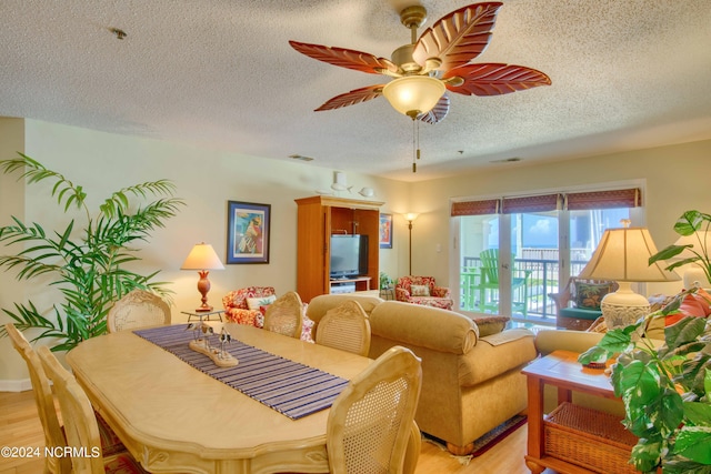 dining area featuring a textured ceiling, light wood finished floors, and a ceiling fan