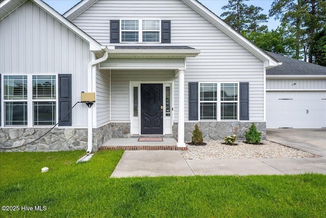 222 Station House Rd, New Bern, NC 28562 - view of front of home featuring stone siding, a garage, a front yard, board and batten siding, and concrete driveway