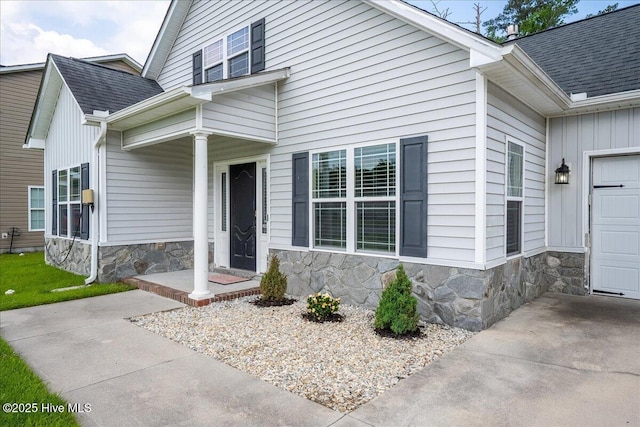 222 Station House Rd, New Bern, NC 28562 - doorway to property with stone siding, a shingled roof, an attached garage, and board and batten siding