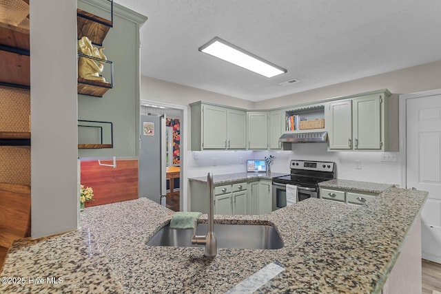 kitchen featuring appliances with stainless steel finishes, open shelves, a sink, under cabinet range hood, and light stone counters