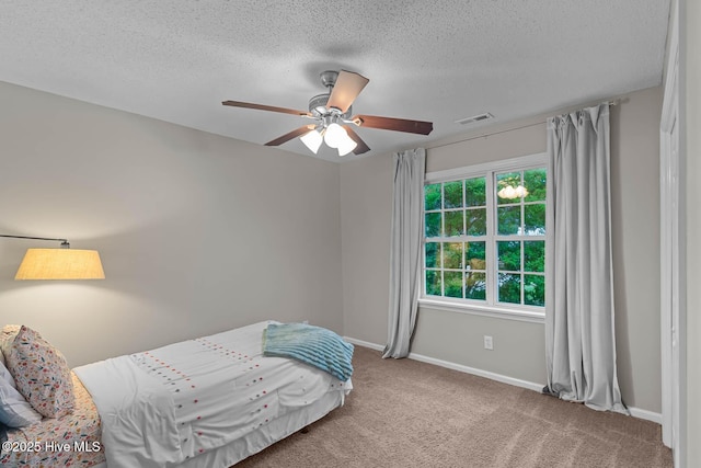 bedroom with baseboards, carpet floors, a textured ceiling, and ceiling fan