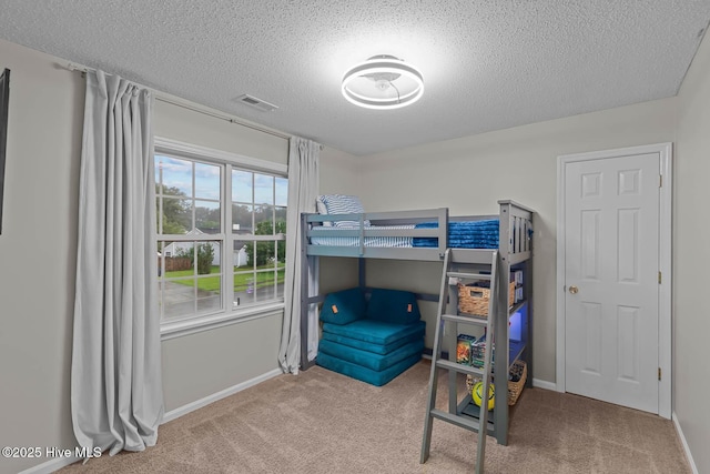 bedroom with carpet floors, a textured ceiling, and baseboards