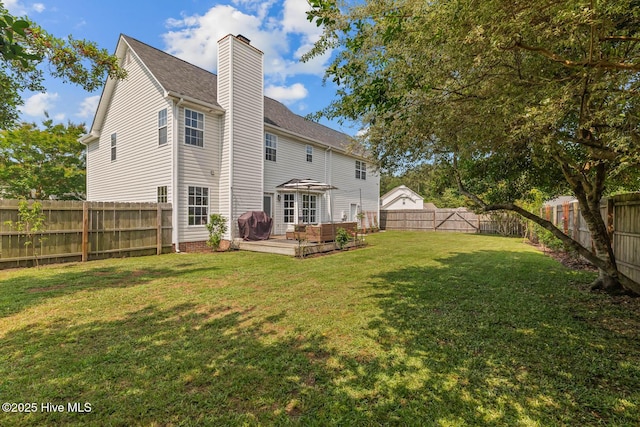 back of property with a chimney, a deck, and a shingled roof