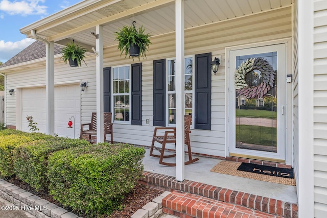 view of exterior entry with covered porch and a garage