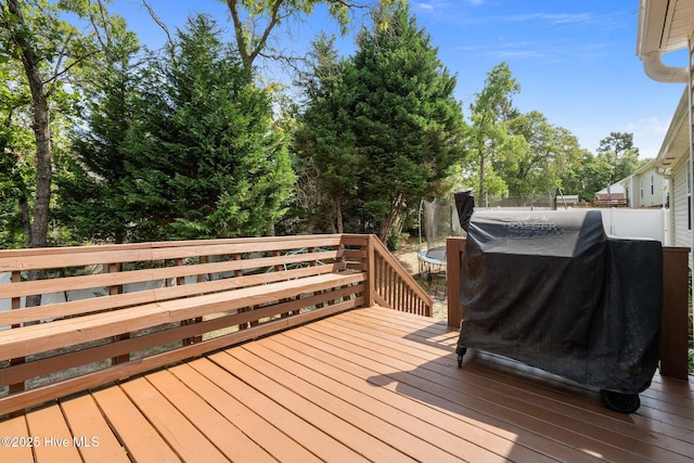 144 Newington Way, Aberdeen, NC 28315 - wooden deck with area for grilling, a trampoline, and view of wooded area