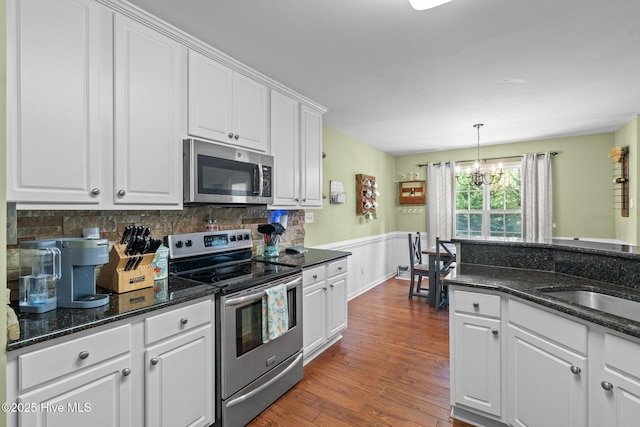 144 Newington Way, Aberdeen, NC 28315 - kitchen featuring appliances with stainless steel finishes, a chandelier, white cabinetry, dark wood finished floors, and tasteful backsplash