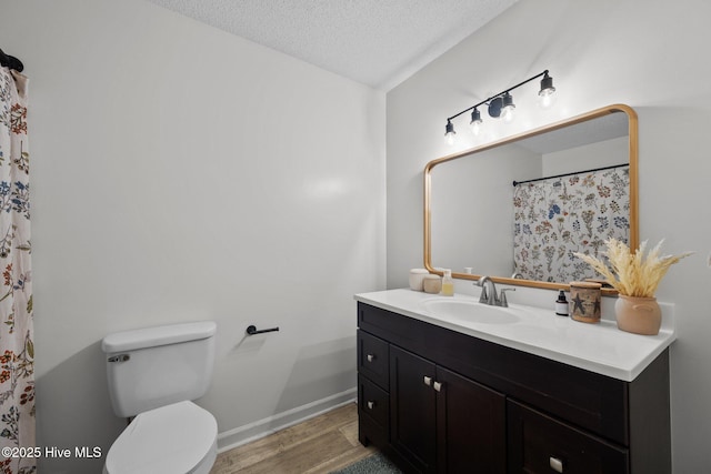 303 Foxtrace Ln, Hubert, NC 28539 - bathroom featuring wood finished floors, toilet, a textured ceiling, vanity, and baseboards
