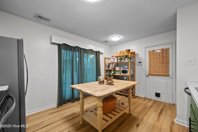 303 Foxtrace Ln, Hubert, NC 28539 - kitchen featuring range, light wood-type flooring, white microwave, a textured ceiling, and baseboards
