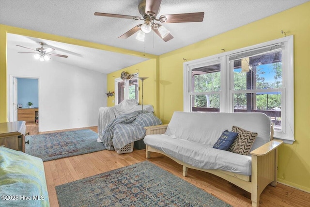 4407 E Oak Island Dr, Oak Island, NC 28465 - bedroom featuring multiple windows, vaulted ceiling, wood finished floors, a textured ceiling, and ceiling fan
