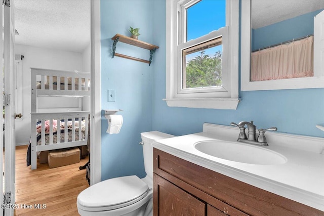 4407 E Oak Island Dr, Oak Island, NC 28465 - bathroom featuring a textured ceiling, toilet, vanity, and wood finished floors