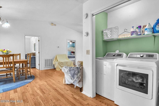4407 E Oak Island Dr, Oak Island, NC 28465 - laundry area with washing machine and clothes dryer, wood finished floors, and a chandelier