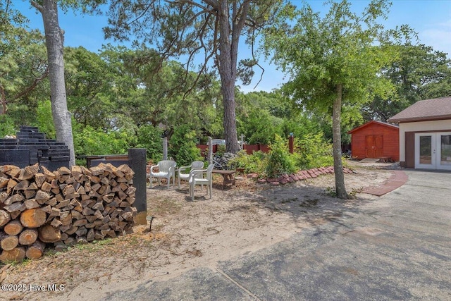 4407 E Oak Island Dr, Oak Island, NC 28465 - view of yard featuring french doors, view of wooded area, and a patio area