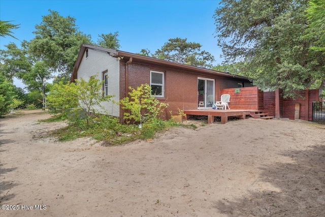 4407 E Oak Island Dr, Oak Island, NC 28465 - rear view of property featuring a wooden deck and brick siding