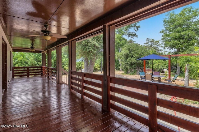 4407 E Oak Island Dr, Oak Island, NC 28465 - wooden deck with ceiling fan and view of scattered trees