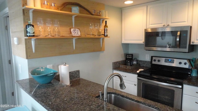 105 Sandy Landing Rd, Cedar Island, NC 28520 - kitchen with appliances with stainless steel finishes, open shelves, a sink, white cabinetry, and dark stone countertops