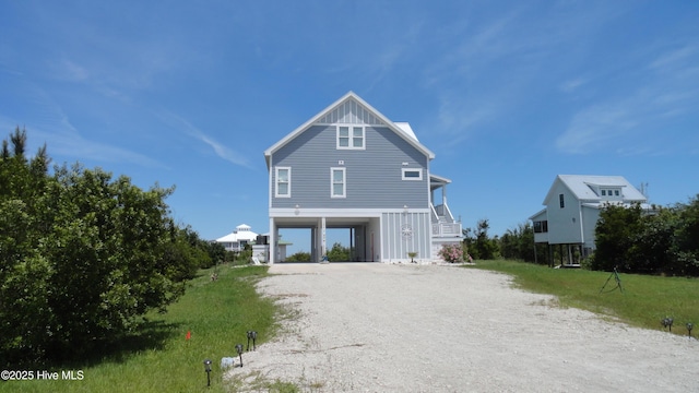 105 Sandy Landing Rd, Cedar Island, NC 28520 - view of front facade featuring a carport, dirt driveway, stairway, and board and batten siding