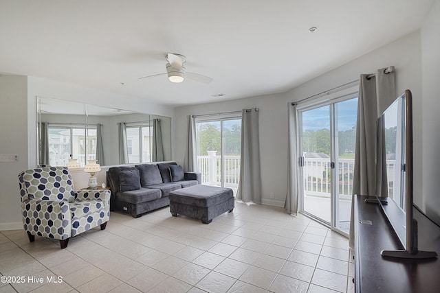 living room featuring a ceiling fan, baseboards, and light tile patterned floors