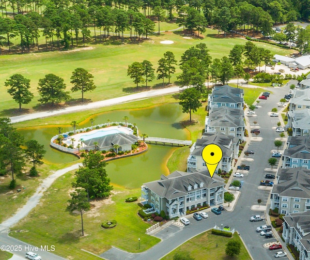 drone / aerial view of a nearby body of water and a local golf course