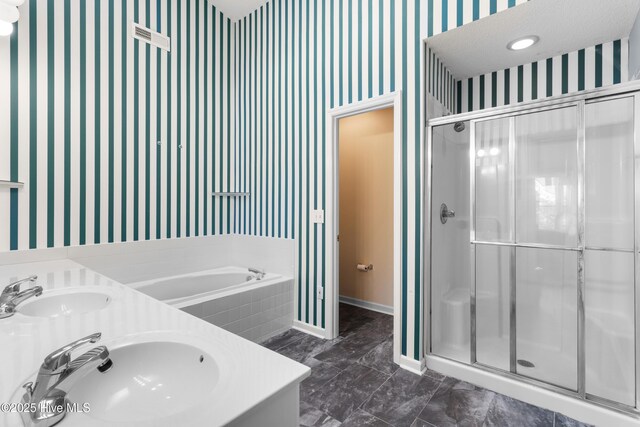 4115 Breezewood Dr Apt 202, Wilmington, NC 28412 - bathroom featuring wallpapered walls, a shower stall, a bath, baseboards, and double vanity