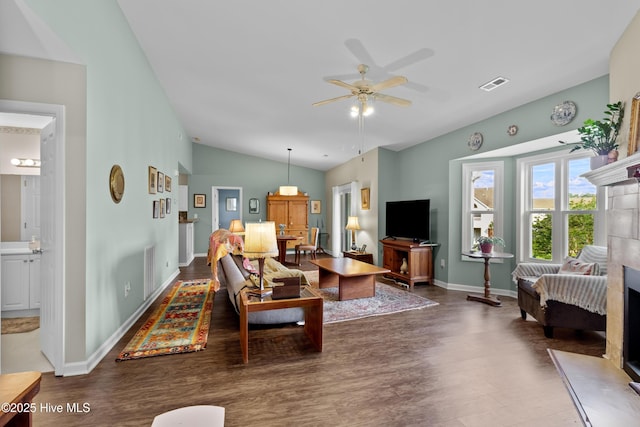 4115 Breezewood Dr Apt 202, Wilmington, NC 28412 - living room with vaulted ceiling, dark wood-style flooring, ceiling fan, a tile fireplace, and baseboards