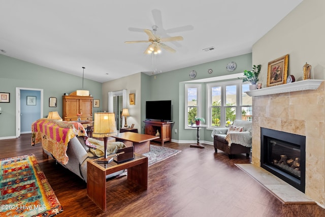 4115 Breezewood Dr Apt 202, Wilmington, NC 28412 - living room featuring dark wood-style floors, a tiled fireplace, a ceiling fan, baseboards, and vaulted ceiling