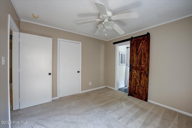 1721 Spencer Ave, New Bern, NC 28560 - unfurnished bedroom with carpet floors, a barn door, ornamental molding, baseboards, and ceiling fan