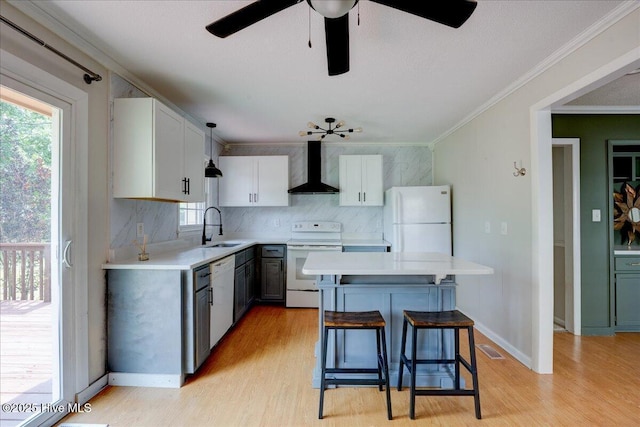 1721 Spencer Ave, New Bern, NC 28560 - kitchen featuring white appliances, wall chimney exhaust hood, light wood-style floors, light countertops, and ornamental molding