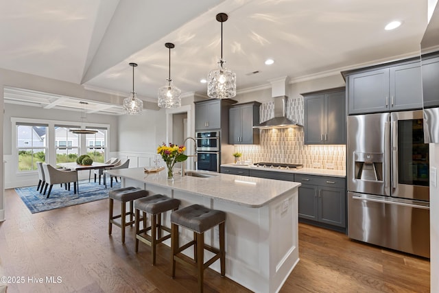 4224 Cobleskill Dr, Leland, NC 28451 - kitchen featuring appliances with stainless steel finishes, a sink, wall chimney range hood, a kitchen island with sink, and a kitchen bar