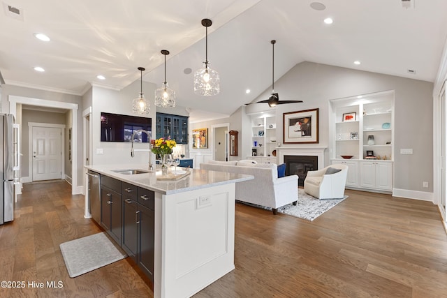 4224 Cobleskill Dr, Leland, NC 28451 - kitchen with a sink, appliances with stainless steel finishes, vaulted ceiling, an island with sink, and wood finished floors
