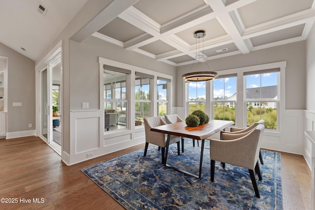 4224 Cobleskill Dr, Leland, NC 28451 - dining area featuring beamed ceiling, a decorative wall, a chandelier, wainscoting, and coffered ceiling