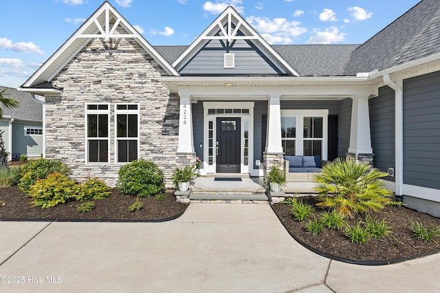 4224 Cobleskill Dr, Leland, NC 28451 - entrance to property featuring stone siding, covered porch, and a shingled roof