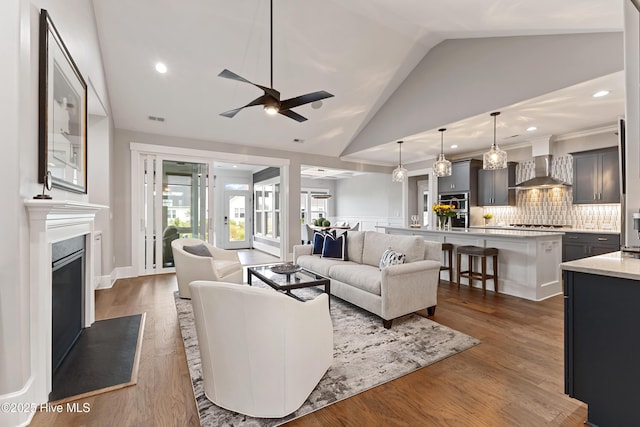4224 Cobleskill Dr, Leland, NC 28451 - living area with lofted ceiling, ceiling fan, a glass covered fireplace, dark wood-type flooring, and recessed lighting