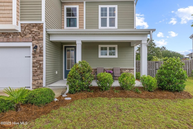 84 Capital Dr, Hampstead, NC 28443 - view of front of house with covered porch, stone siding, and a garage