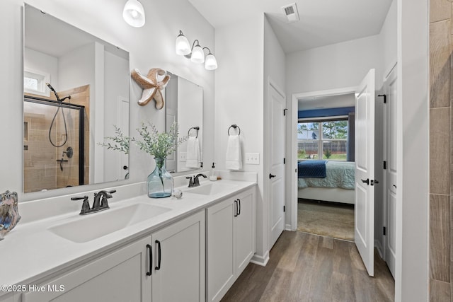 84 Capital Dr, Hampstead, NC 28443 - ensuite bathroom featuring wood finished floors, a shower stall, and double vanity