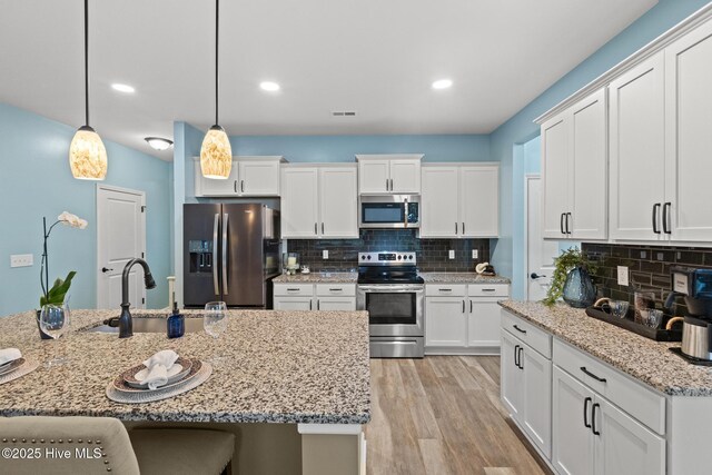 84 Capital Dr, Hampstead, NC 28443 - kitchen featuring appliances with stainless steel finishes, a sink, backsplash, white cabinets, and recessed lighting